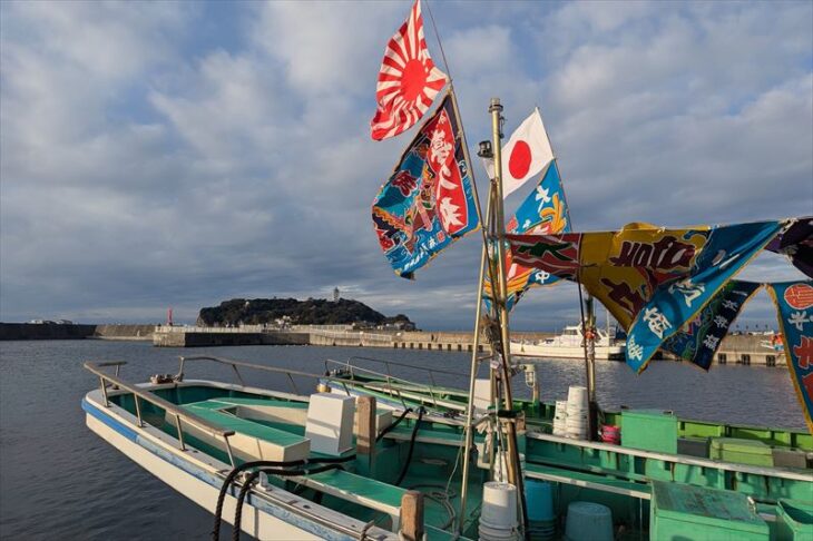 大漁旗を飾った漁船と江ノ島