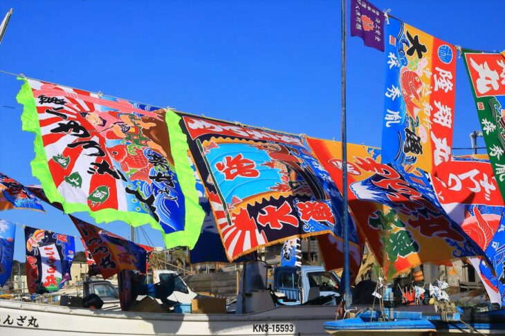 材木座海岸の船おろしで漁船に飾られた大漁旗